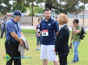 Roland Esquivel, Rick Rams, and JoAnna Schilling standing on lawn before Veterans 5k