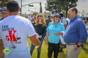 Men and women laughing together on lawn at veterans 5k