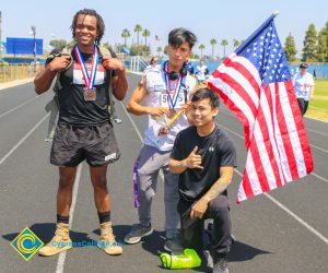 Three men with medals, one is holding an American flag