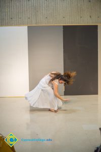 Woman in a dress doing a dance performance.