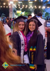 Students pose in graduation regalia at commencement