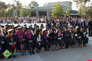 Students read programs at commencement