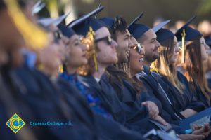 Graduates smile in the audience at commencement