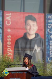 A student speaks onstage during commencement