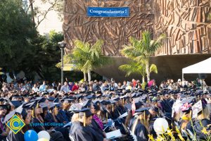 A banner reads "Congratulations!" on the mural in the background at commencement