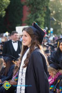 A graduate in a Student Athlete sash stands at commencement