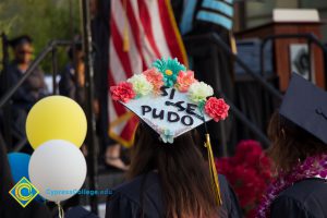 A graduation cap reads "Si se pudo" at commencement