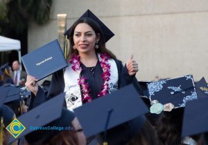 A graduate stands and looks at the audience at commencement