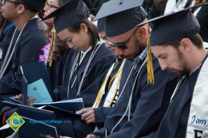 Students read their programs at commencement