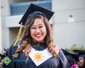 A graduate poses for a photo at commencement