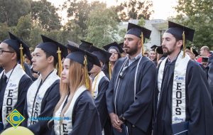 Graduates in EOPS sashes stand at commencement