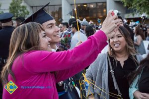 People pose for a selfie at commencement