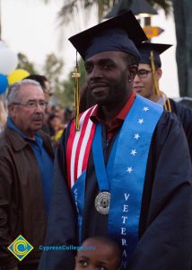 A graduate with a Veterans Resource Center sash at commencement