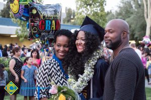 A family poses with a graduate at commencement