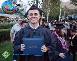 A student holds a diploma at commencement