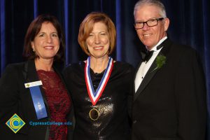 A woman with short brown hair, a woman in a black dress and President Bob Simpson smiling during the 40th Annual Americana Awards.