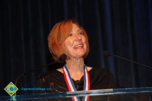 A woman with short red hair smiling.