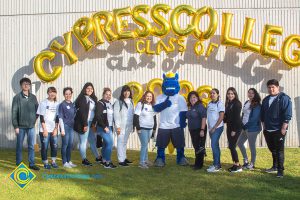 Dr. Therese Mosqueda-Ponce wtih a group of students standing under Cypress College Class of 2033 balloon arch