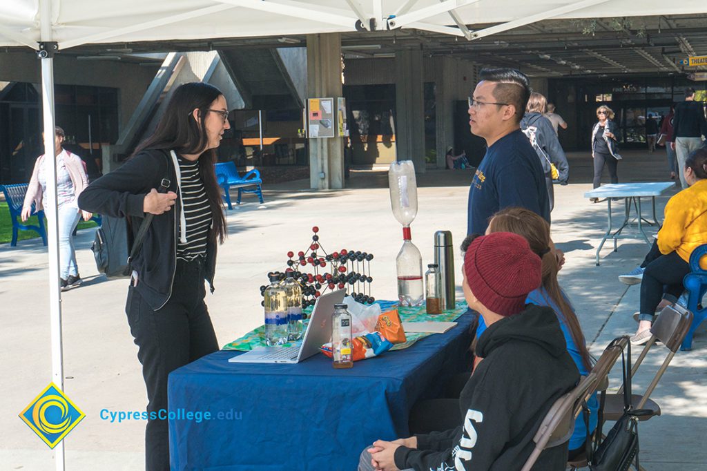 Display table set up with representatives speaking to students.