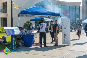 Students gathered under a canopy in the gateway plaza.