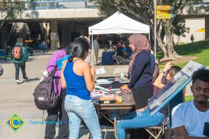 Students at a display table on campus.