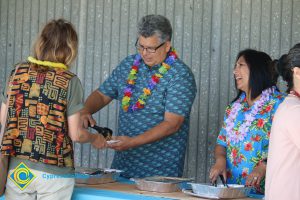 Michael Brydges and Ruth Gutierrez serving food at end-of-the-year luau