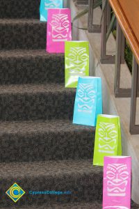 Pink, green, and blue bags lined up on stairs