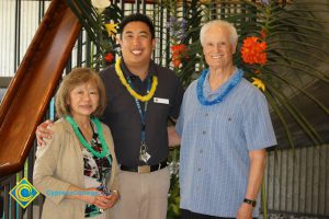 Dean Henry Hua and two other employees all wearing leis at end-of-the-year luau