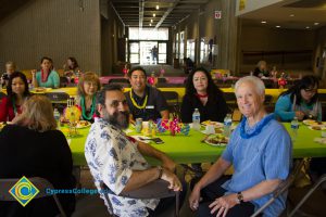 Employees sitting at table at end-of-the-year luau