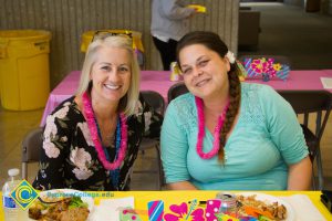 Two female employees at end-of-the-year luau
