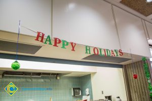 Happy Holidays banner decoration with a green and a red ornament hanging on each end.