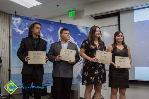 Four students holding award certificates.