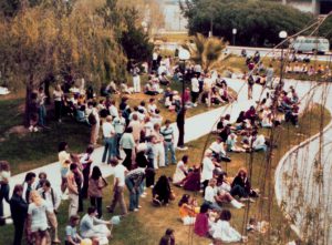 Students gathered on campus near the pond.