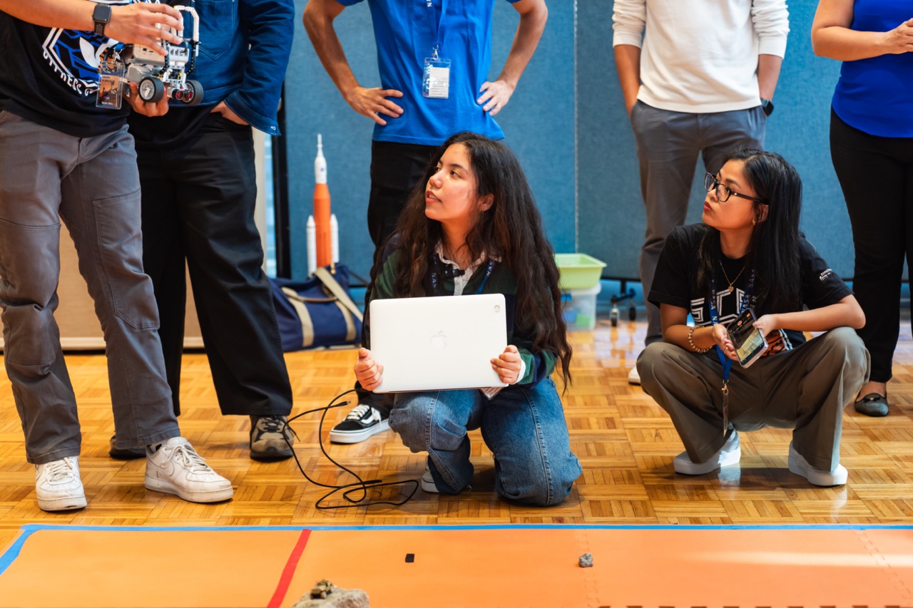 Students prepare their robotic rover for competition in a NASA event.