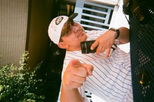 Student photographer poses on campus. Photo taken for Disposable Camera Project.