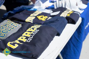 Cypress College shirts folded on a table.