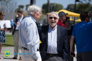 Two men talking and laughing at the 50th Anniversary celebration.