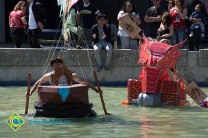 Handmade Rowboats in the school pond as people cheer them on.