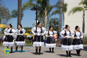 Women in black and white dresses dancing at the 50th Anniversary Festival and Reunion.