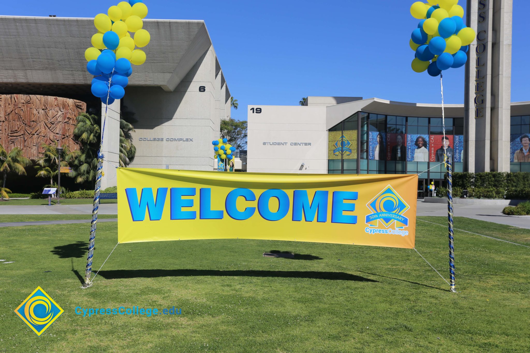Welcome banner with a bunch of yellow and blue balloons on each side.