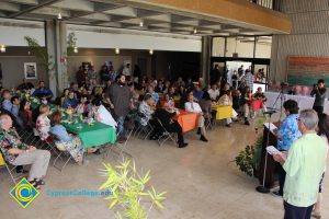 Staff listening to speaker at the End of the Year Luau.