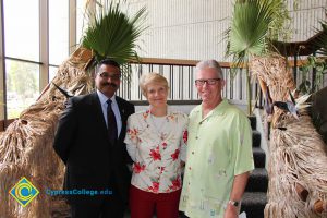 President Bob Simpson and Santanu Bandyopadhyay with a woman in a red floral shirt.