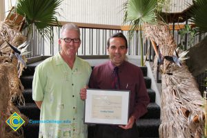 President Bob Simpson and Eldon Young holding an award.