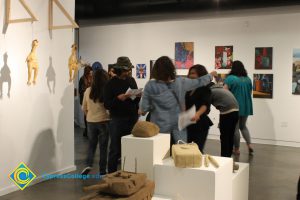 Students looking at artwork on a gallery wall.