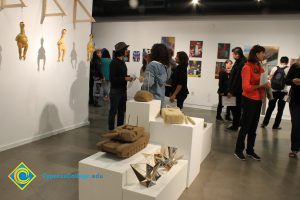 Students looking at artwork on a gallery wall.