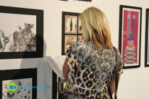 A woman looking at artwork displayed on a gallery wall.