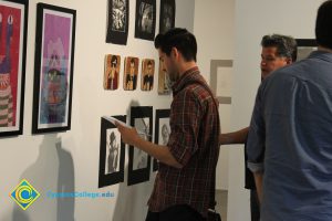 Students looking at artwork on a gallery wall.