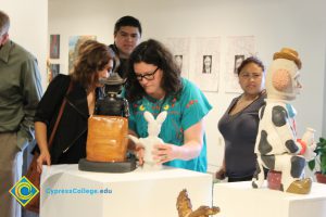 People looking at ceramic pieces on display.