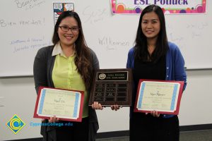 Two young ladies holding awards.