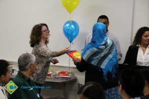 Staff members handing out books at the ESL Scholarship Potluck.